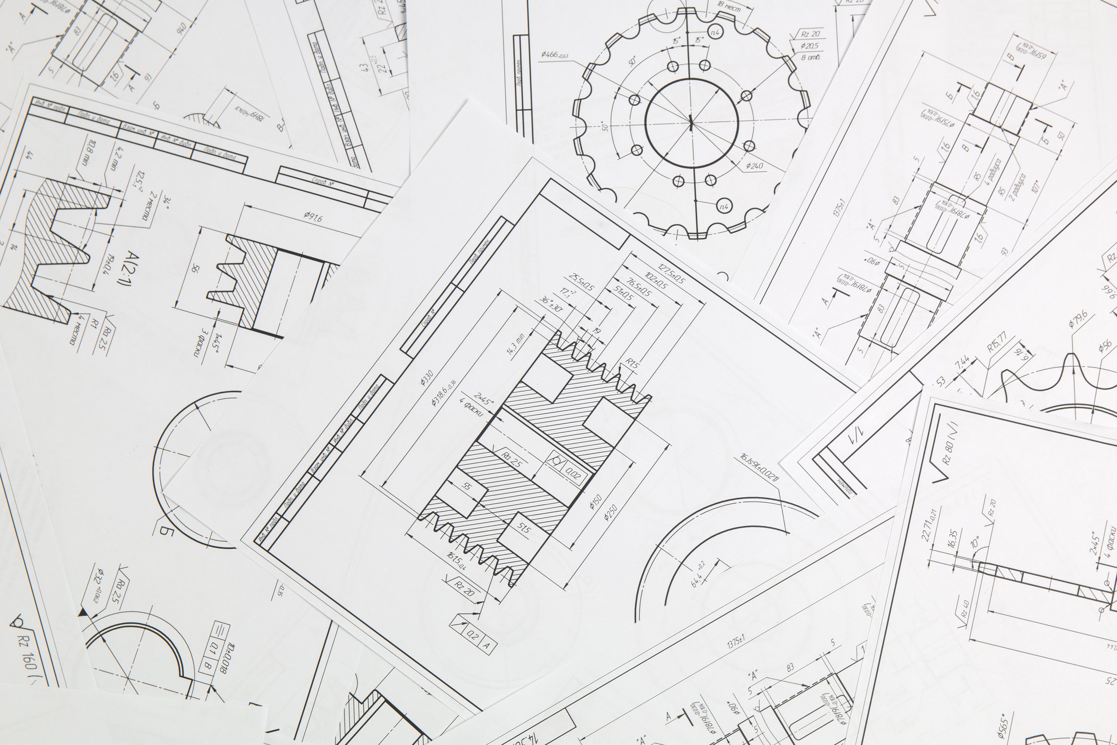 paper engineering drawings of industrial parts and mechanisms